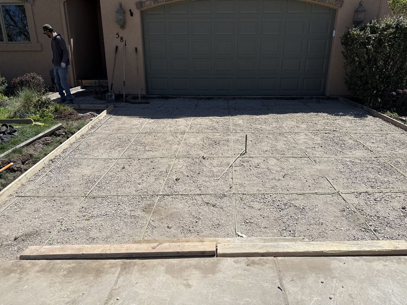 Forming a new driveway at a stucco house.